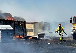 Los bomberos tratan de apagar las llamas en las casetas de Santa Marta.