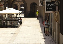 Paseanes se resguardan del calor en la sombra.