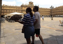 Varias personas pasean por la Plaza Mayor de Salamanca durante un soleado día.