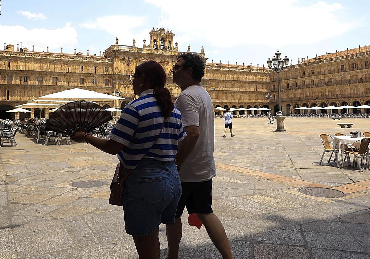 Varias personas pasean por la Plaza Mayor de Salamanca durante un soleado día.