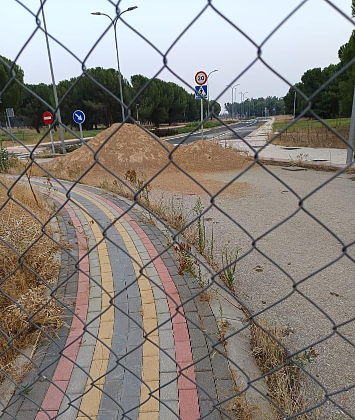 Imagen secundaria 2 - Cartel de la inmobiliaria que ha intentado vender el terreno, césped y una acera de la urbanización, sin estrenar.