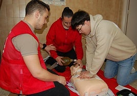 Formadores de Cruz Roja enseñando a hacer una reanimación cardiopulmonar.