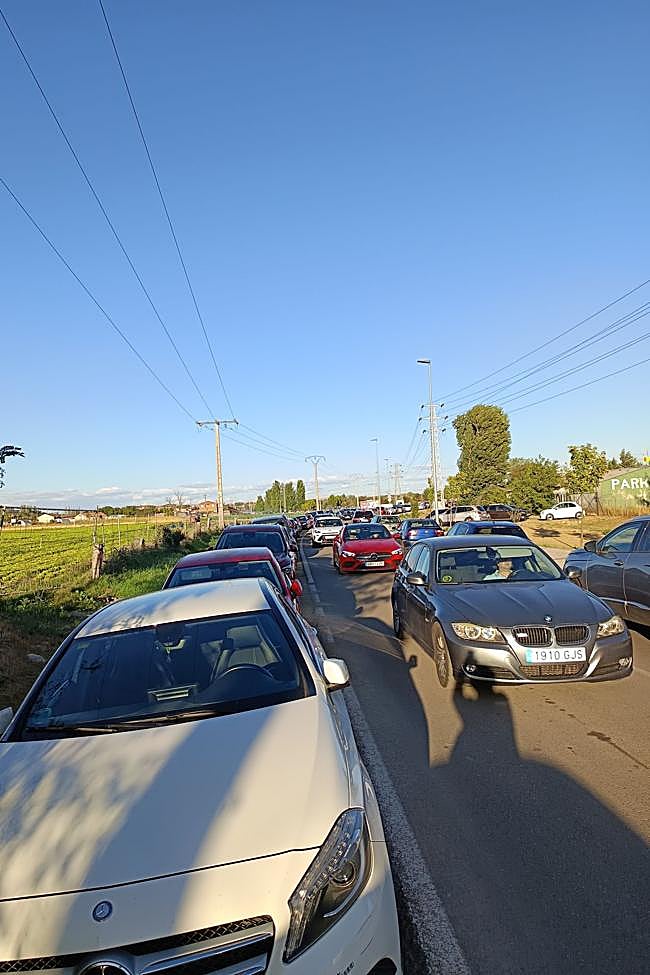 Dos carriles ocupados y coches en los arcenes en La Aldehuela.