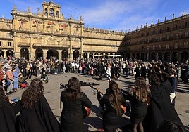 Turistas junto a una tuna en la Plaza Mayor de Salamanca.