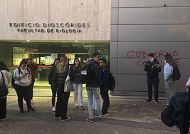 Un operario trata de limpiar una pintada realizada en una facultad.