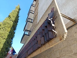La pieza metálica que decora la fachada del instituto lleva meses vallada por seguridad.