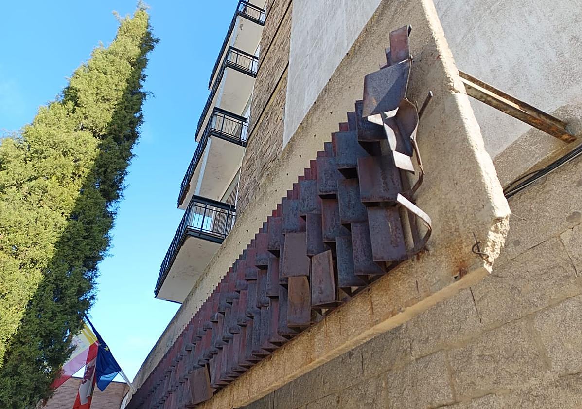 La pieza metálica que decora la fachada del instituto lleva meses vallada por seguridad.