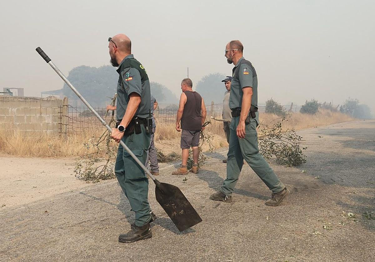 Dos guardias civiles y vecinos ayudan a apagar el incendio de Cipérez.