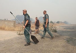 Dos guardias civiles y vecinos ayudan a apagar el incendio de Cipérez.
