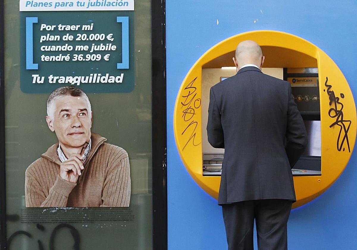 Una persona saca dinero de un cajero automático en una imagen de archivo.