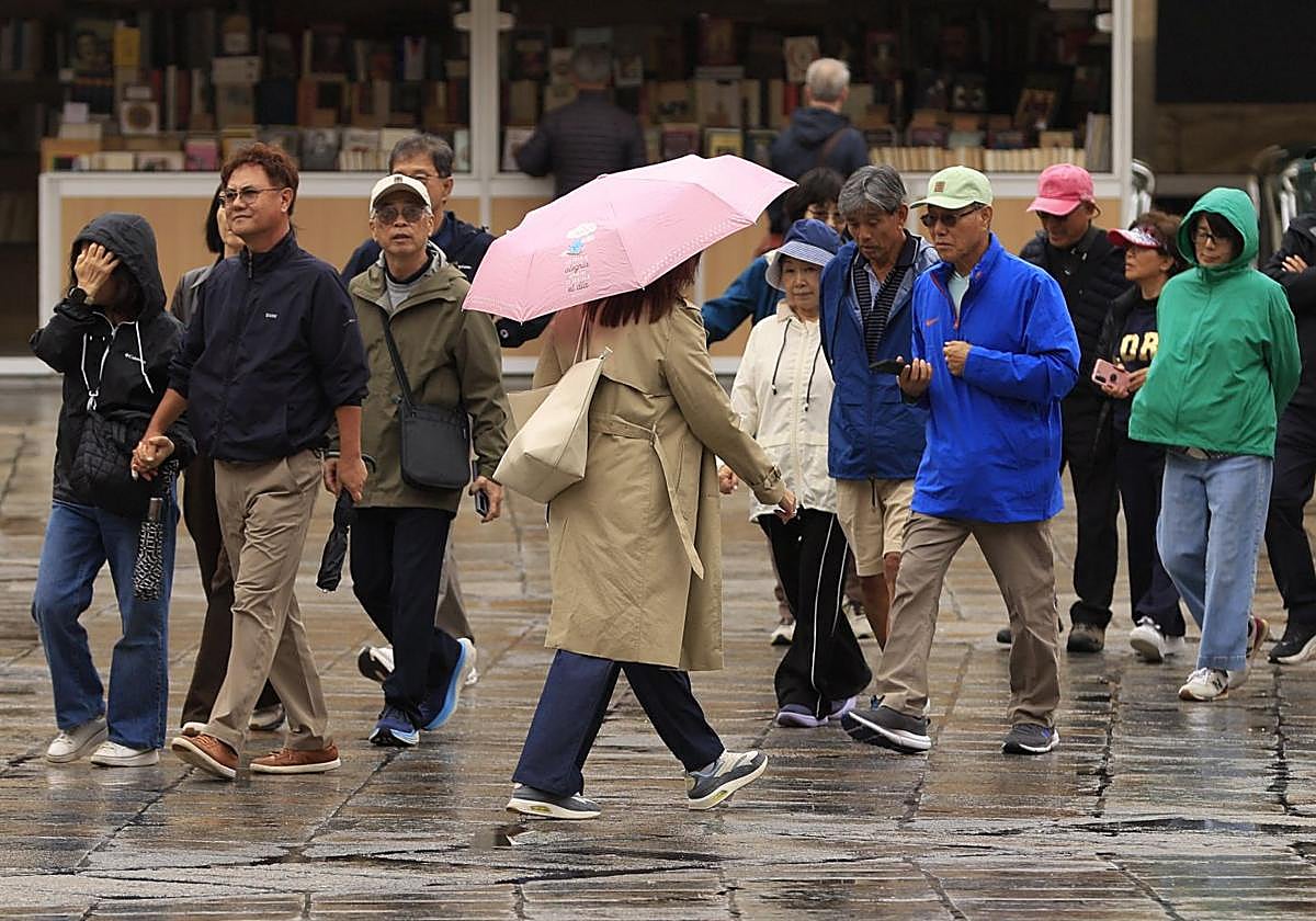Varias personas pasean por la Plaza Mayor de Salamanca en un día de lluvia.