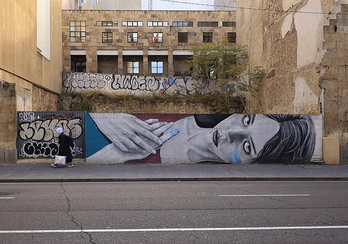 Imagen principal - Varias vistas del mural en su estado actual y la firma del artista.