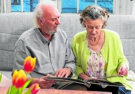 Älteres Paar schaut Familienfotos an.