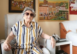 Trinidad posiert im Wohnzimmer ihres Hauses vor drei Bildern, die sie malte, nachdem sie im Alter von 70 Jahren zu malen begann.