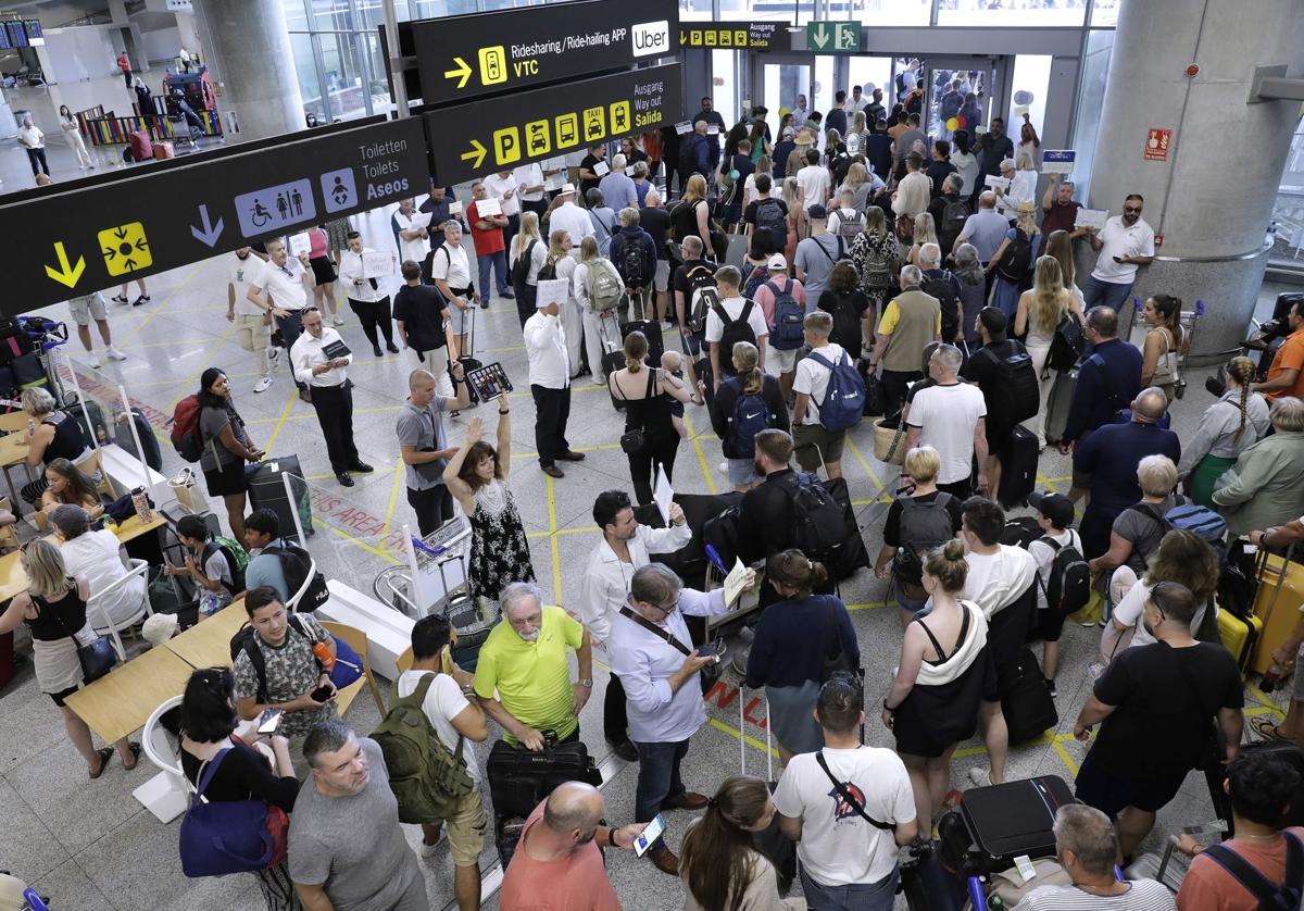 Passagiere mit Koffern am Flughafen von Málaga.