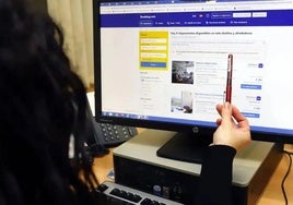 Frau sucht Unterkunft auf Website von Booking.com.