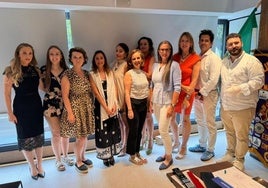 Präsidentin Trinidad Casanova im roten Kleid umringt von Mitgliedern.