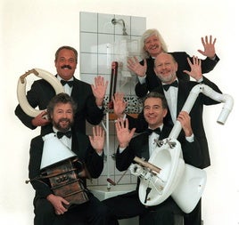 Mitglieder der Gruppe Les Luthiers mit typischen Instrumenten.