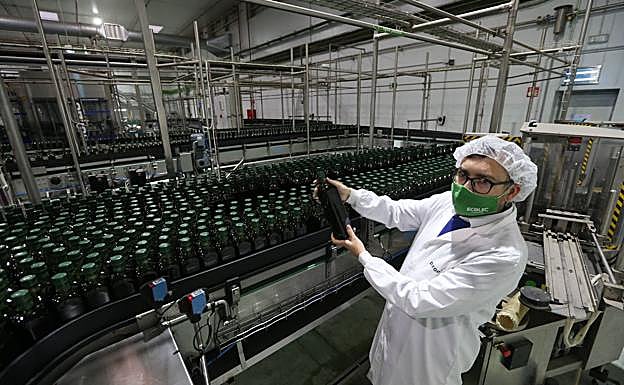 Esteban Carneros holds up a one-litre bottle.