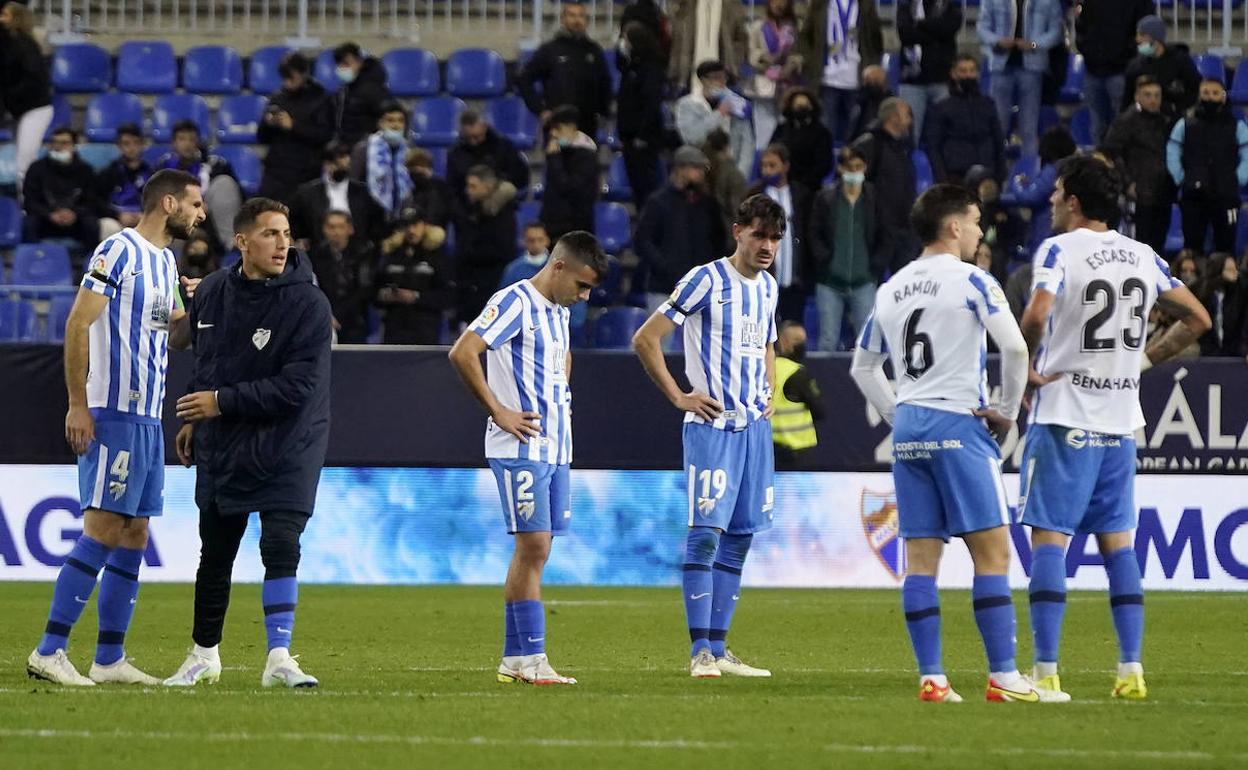 Dejected Malaga players after the final whistle. 