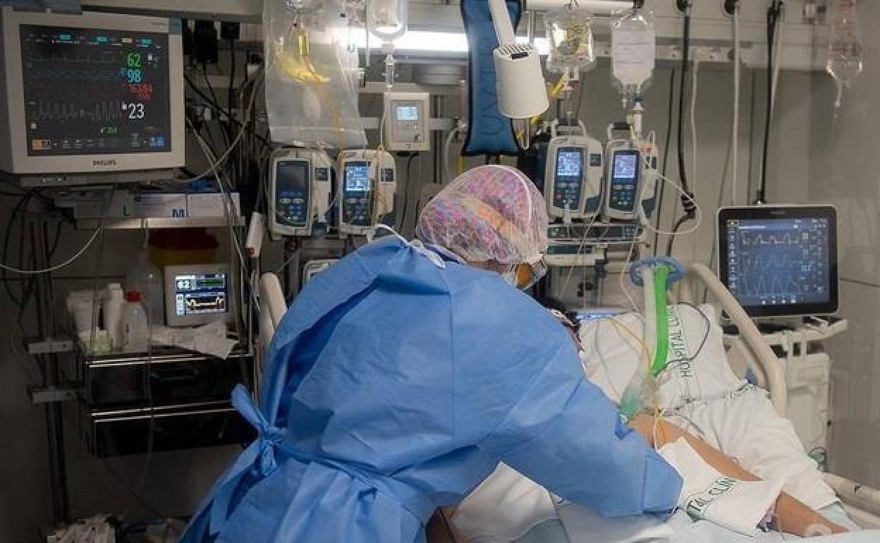 A nurse attends to a patient in a hospital in Catalonia. 