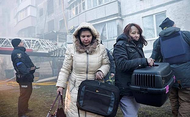 Two women flee from a building that had just been bombed.