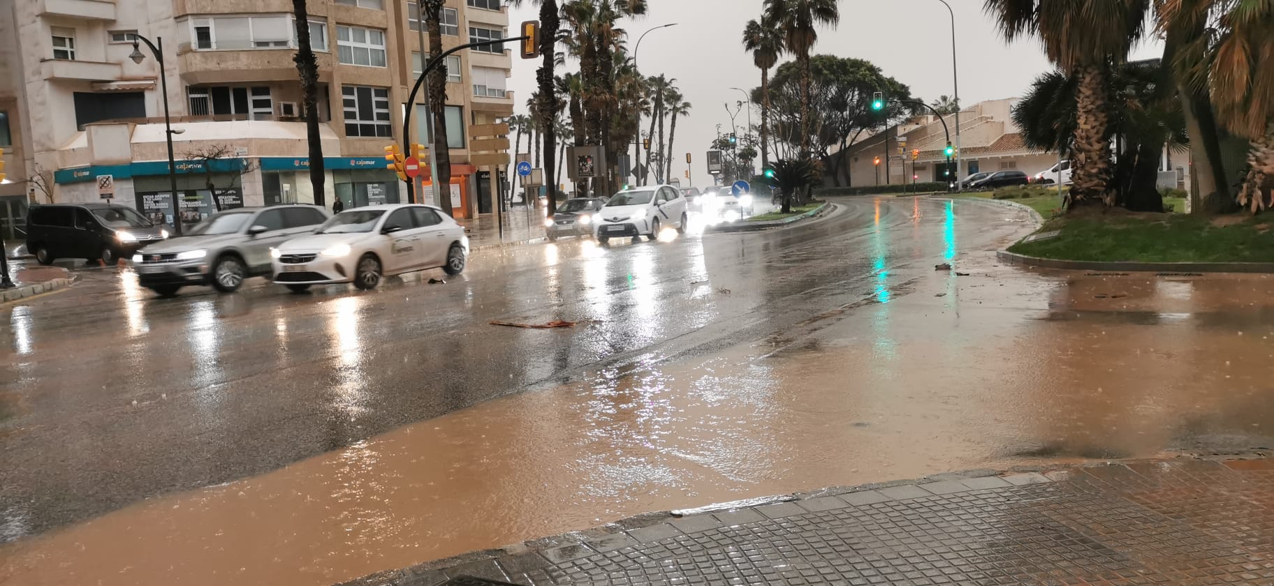 Malaga wakes to cars, buildings and streets covered in red mud