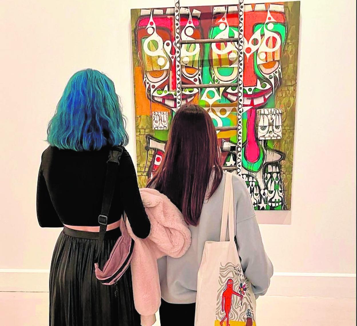 Visitors examine a Phil Frost work at CAC Malaga. 