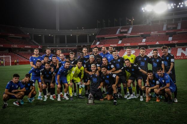 Malaga players pose with their second pre-season trophy after beating Granada on penalties. 
