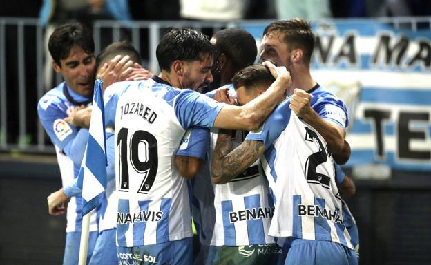 Malaga players celebrate the goal that was enough to win the game.