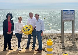 Ana Mula (2nd left) inspects one of the acoustic beacons on Las Gaviotas beach.