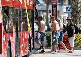 Tourists board a sightseeing bus in Malaga city.