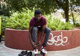 A man fastens his roller skates.