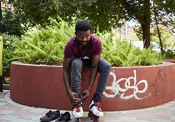 A man fastens his roller skates.