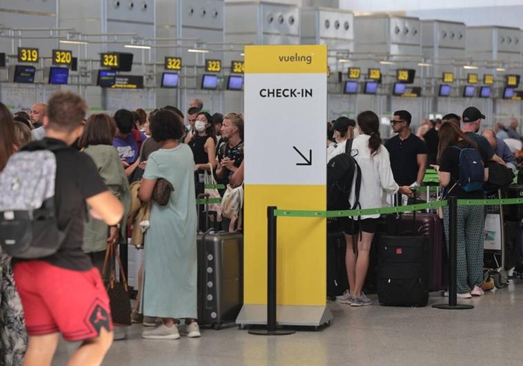Passengers queue at the check-in counters at Malaga Airport. S