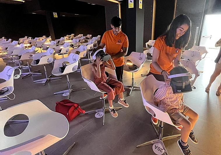 Two youngers trying out the immersive experience in the Cueva de Nerja.