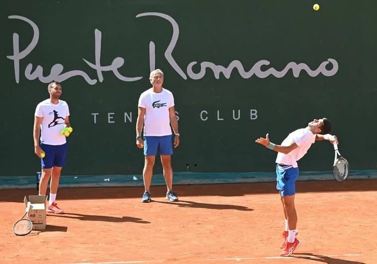 Djokovic practises a serve in front of his trainers Carlos Gómez Herrera and Goran Ivanisevic.