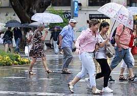 File image of people braving the rain in Malaga centre recently.