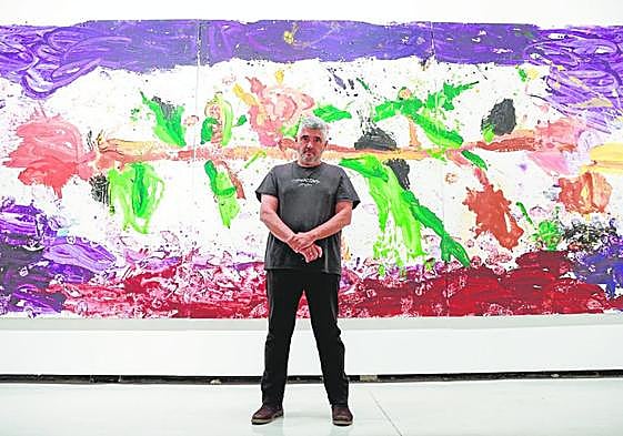 Jorge Galindo, standing before the triptych The Roses of Hercules.