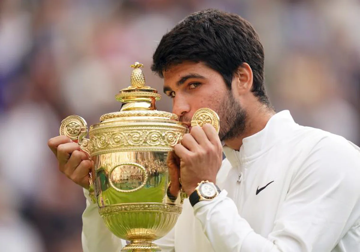 Alcaraz kisses the Wimbledon trophy on Sunday.