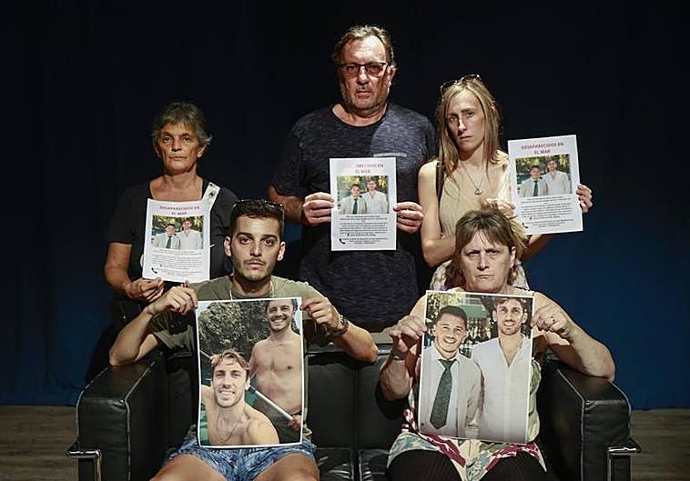 Relatives of Emma and Maxi, with the posters of the two missing young people.