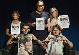 Relatives of Emma and Maxi, with the posters of the two missing young people.