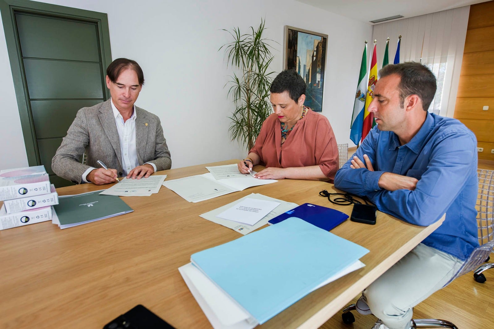 Juan Antonio de Luque Ibáñez and Margarita del Cid sign the agreement.