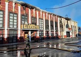 A firefighter walks past the ruins of Teatre and Fonda Milagros (right) last Sunday. Neither had a valid licence.