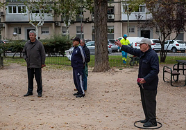 A group of elderly people playing petanque.
