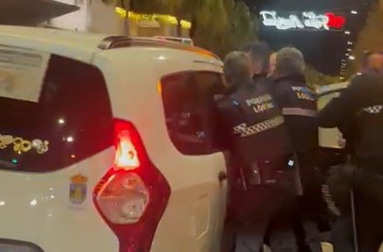 In the image, recorded by a passer-by, the officers apprehend the suspect before he left a taxi.