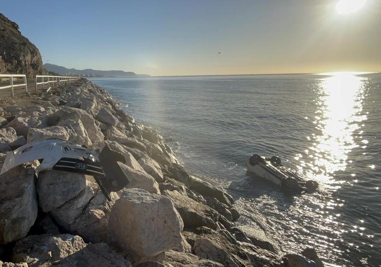 The overturned vehicle lies in the sea after crashing over the Calaceite breakwater from the old N-340 in Torrox-Costa.