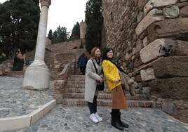 Two Asian tourists take a selfie before entering the Alcazaba.