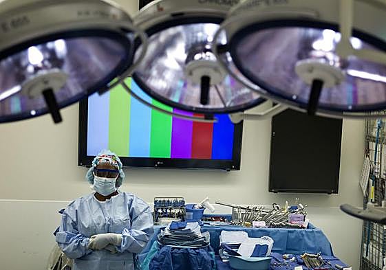 A healthcare worker prepares surgical equipment for a transplant.