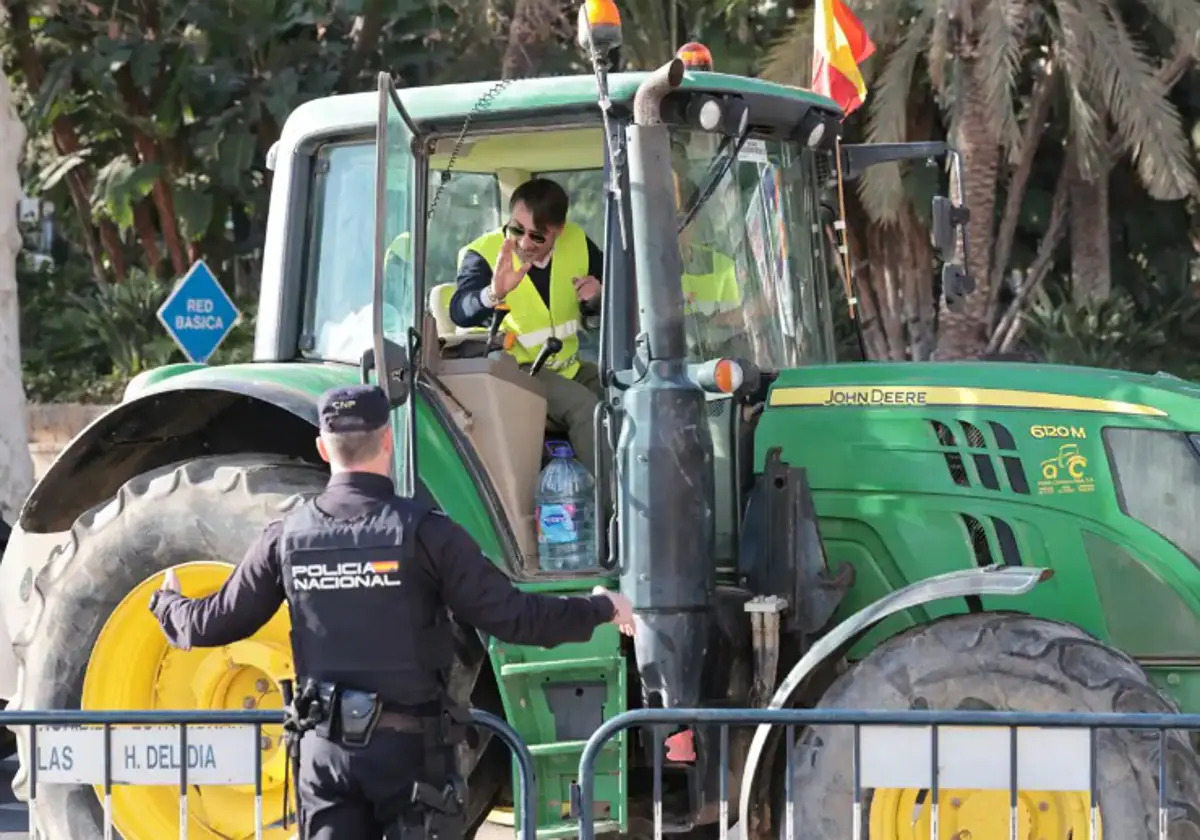 A National Police officer talking to a tractor driver in Malaga city on Tuesday.